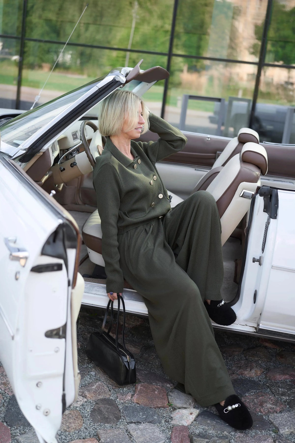 woomen in Urushadze green knitt suit sitting in white Cadilac