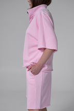 Person wearing a pink outfit on a gray background pink