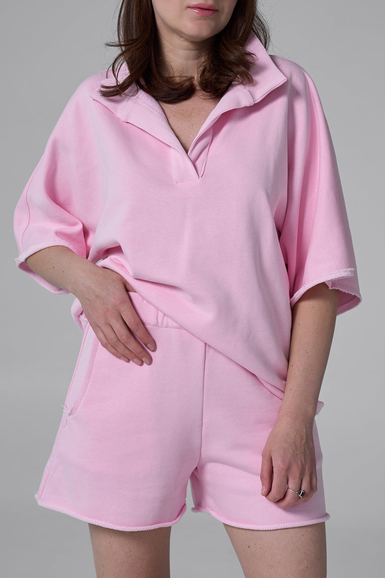 Person wearing a pink pajama set on a gray background pink