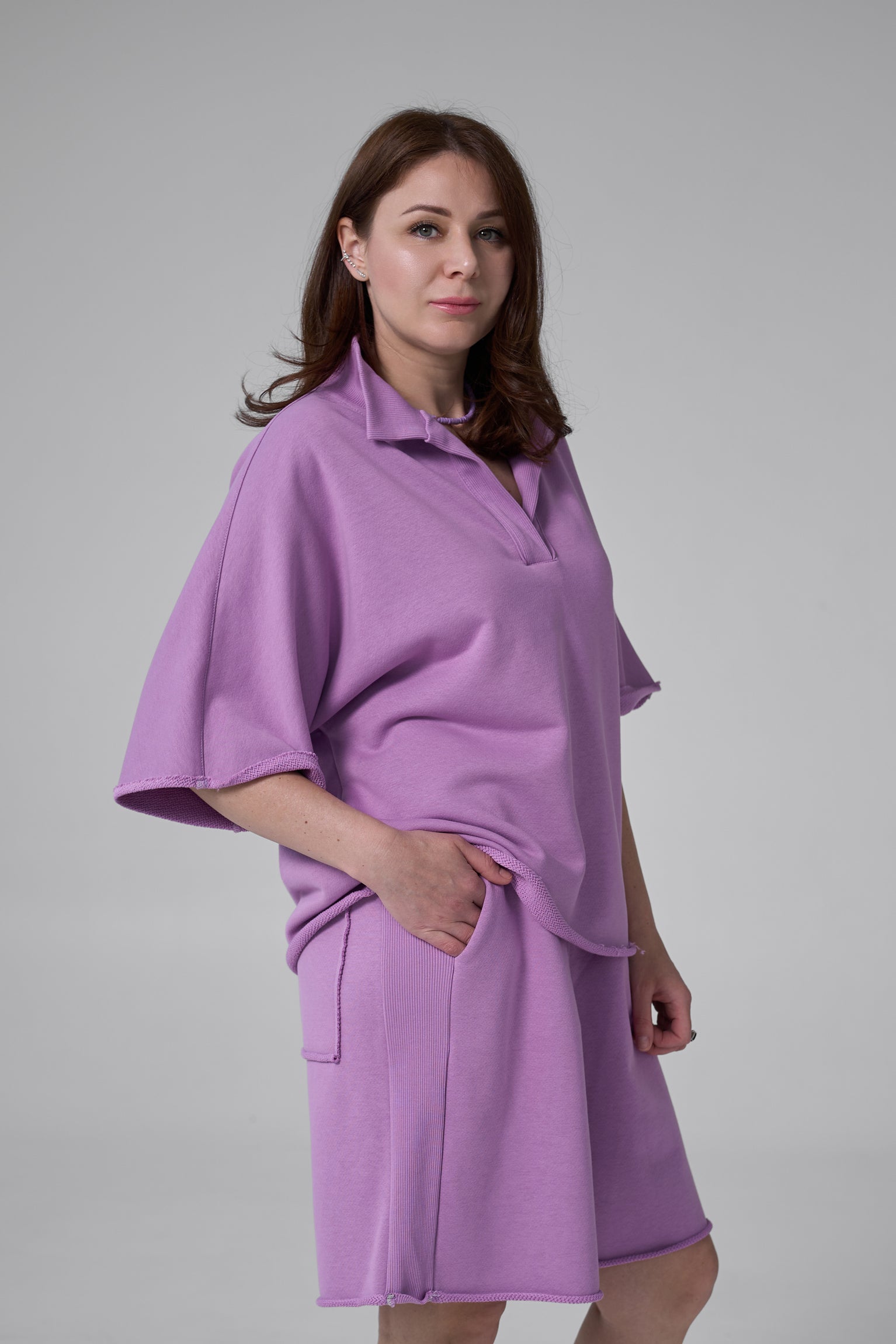 Woman wearing a purple dress against a gray background purple
