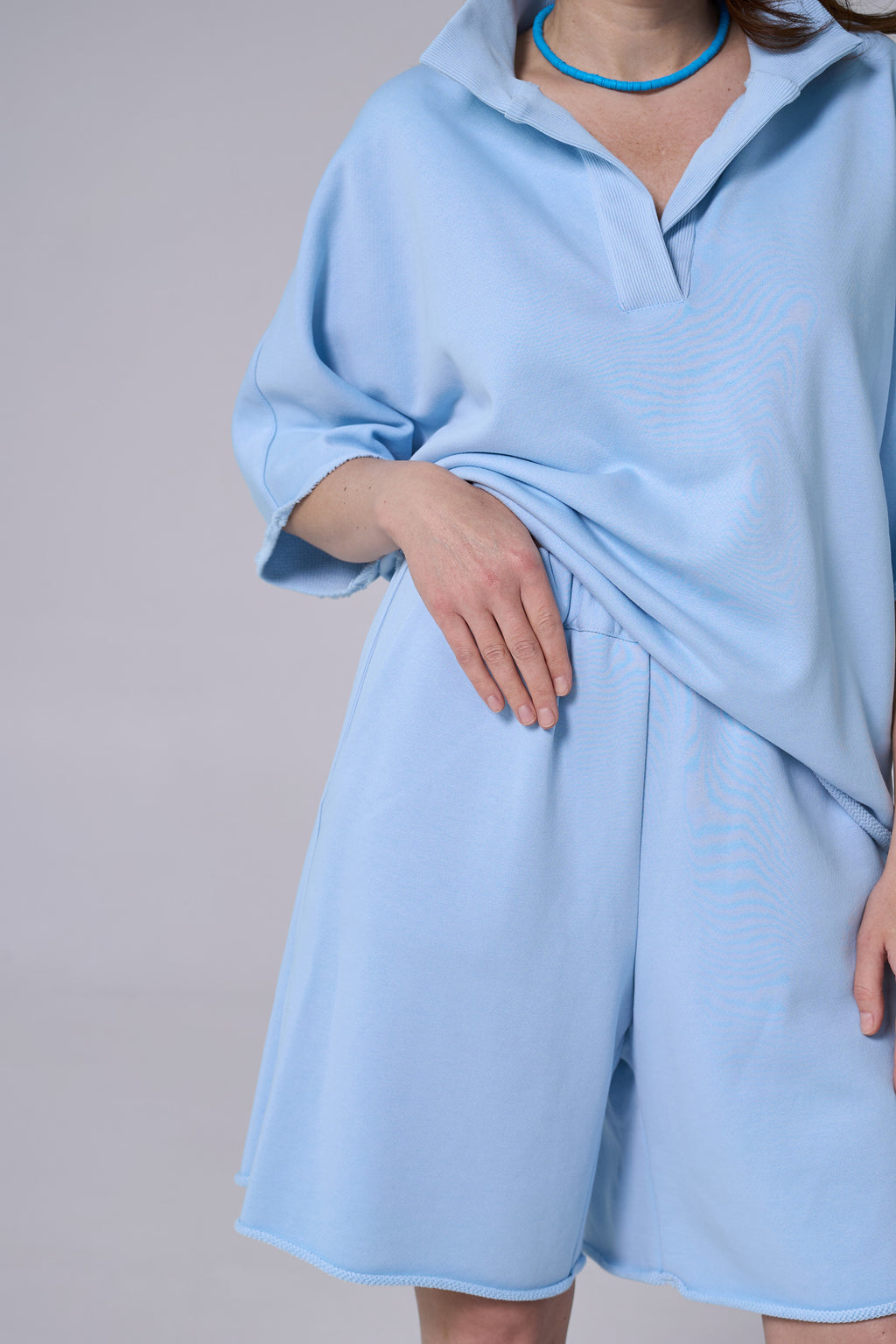 Light blue dress worn by a person on a plain background light blue