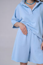 Light blue dress worn by a person on a plain background light blue