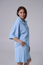 Woman wearing a light blue dress against a plain background light blue 
