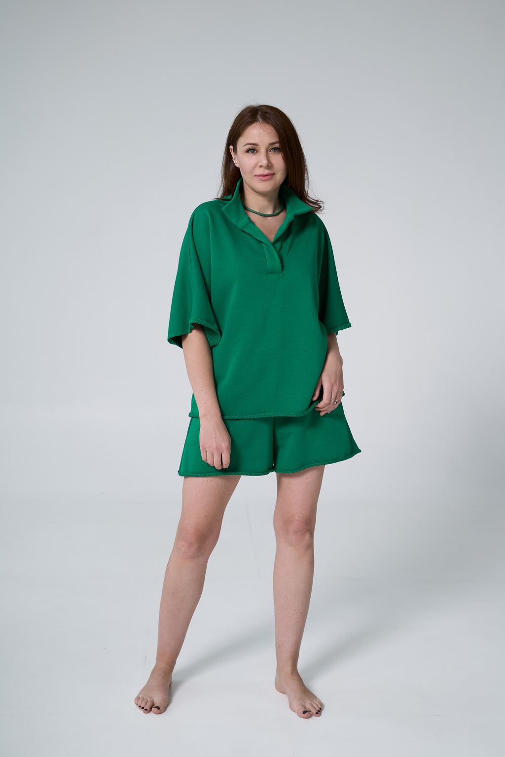 Woman wearing a green outfit on a white background emerald