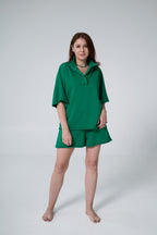 Woman wearing a green outfit on a white background emerald