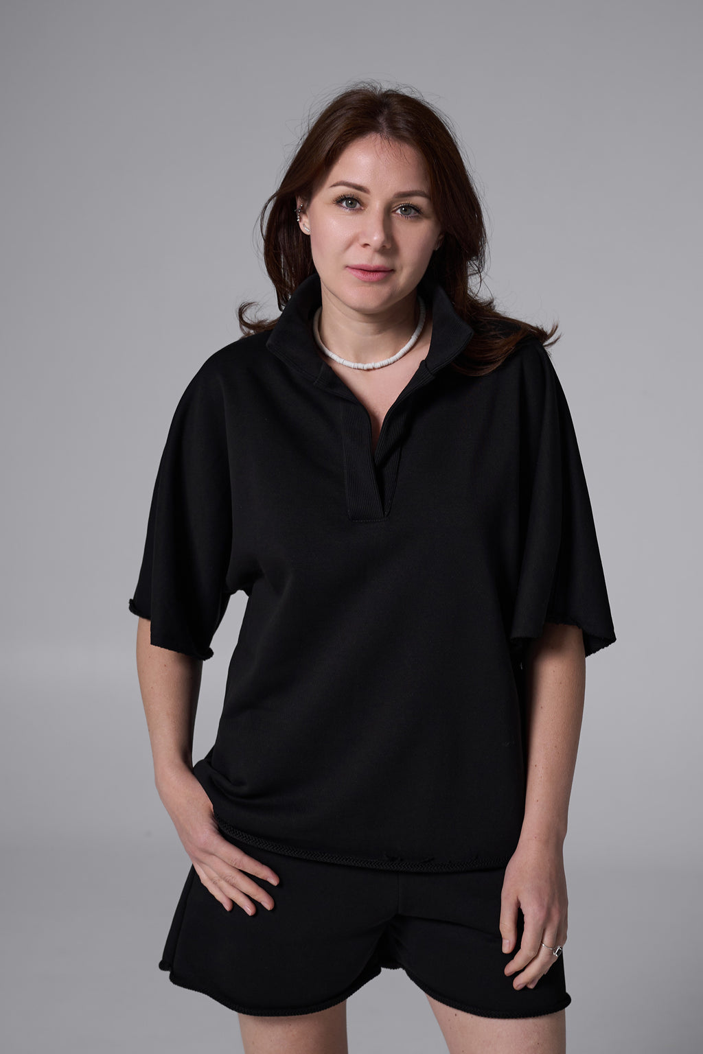 Woman wearing a black outfit against a gray background black