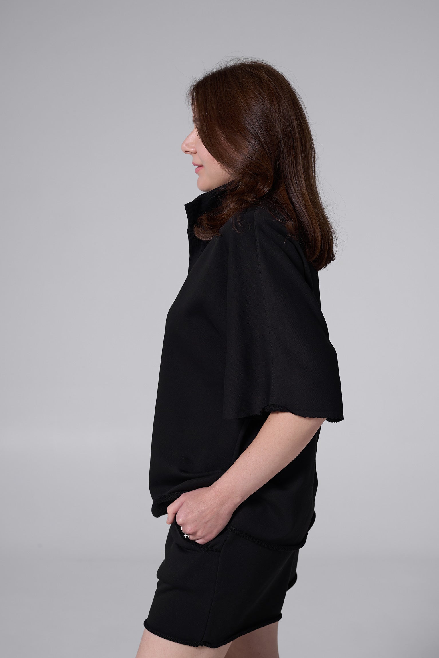 Woman wearing a black dress against a gray background black