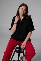 Woomen sitting on a chair in black tshirt  an red pants black