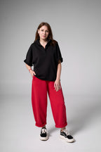 Person wearing a black shirt and red pants on a gray background black