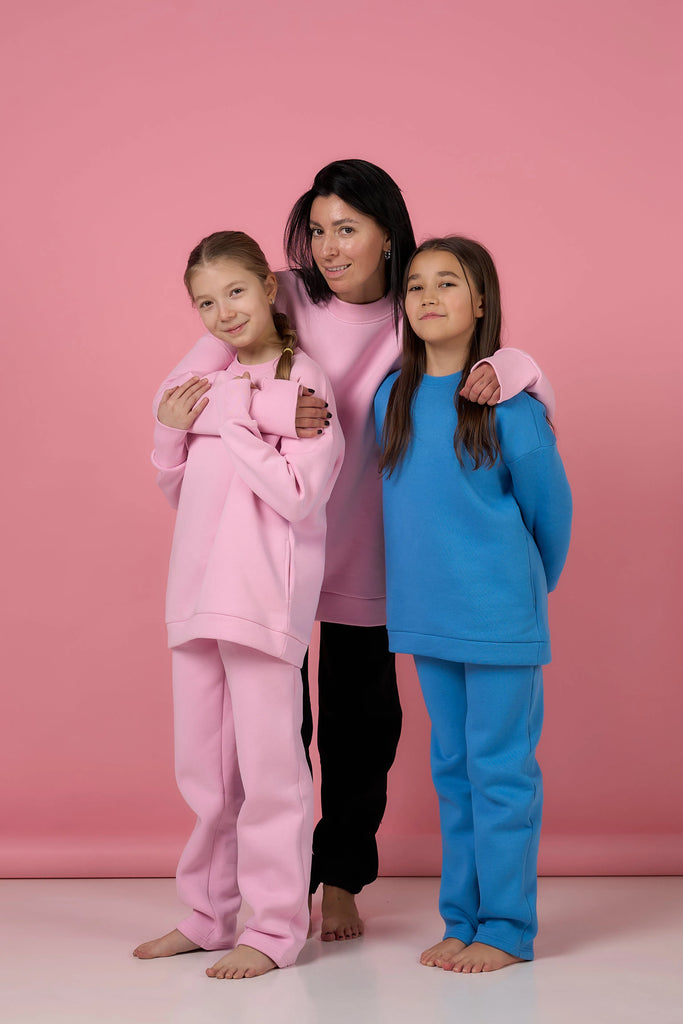 three girls standing
 in Mamba kids blue and pink suit 
